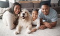 Portrait of a happy mixed race family of three relaxing on the lounge floor with their dog. Loving black family being Royalty Free Stock Photo