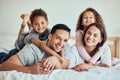 Portrait of happy mixed race family with two children lying on the bed at home. Smiling couple bonding with their son Royalty Free Stock Photo