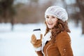 Portrait of happy modern woman outside in city park in winter