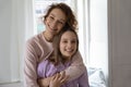 Portrait of happy mom and teen daughter hugging