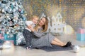 Portrait of happy mother and adorable baby celebrate Christmas. New Year`s holidays. Toddler with mom in the festively decorated Royalty Free Stock Photo