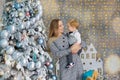 Portrait of happy mother and adorable baby celebrate Christmas. New Year`s holidays. Toddler with mom in the festively decorated Royalty Free Stock Photo