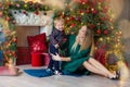 Portrait of happy mother and adorable baby celebrate Christmas. New Year`s holidays. Toddler with mom in the festively decorated Royalty Free Stock Photo