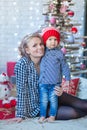 Portrait of happy mother and adorable baby celebrate Christmas. New Year`s holidays. Toddler with mom in the festively decorated r Royalty Free Stock Photo