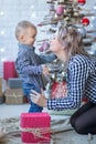 Portrait of happy mother and adorable baby celebrate Christmas. New Year`s holidays. Toddler with mom in the festively decorated r Royalty Free Stock Photo