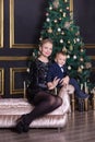 Portrait of happy mother and adorable baby celebrate Christmas. New Year`s holidays. Toddler with mom in the festively decorated r Royalty Free Stock Photo