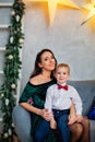 Portrait of a happy mother and a charming child celebrating Christmas. New year holiday. Baby with his mother in a festively Royalty Free Stock Photo