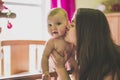 Portrait of a happy mother with cute baby in crib giving kiss Royalty Free Stock Photo