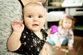 Portrait of a happy mother with cute baby at home with sister on the back Royalty Free Stock Photo