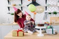 Portrait of happy mother and daughter on her first birthday party, indoors Royalty Free Stock Photo