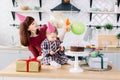 Portrait of happy mother and daughter on her first birthday party, indoors Royalty Free Stock Photo