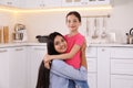 Portrait of mother and daughter hugging in kitchen. Single parenting