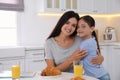 Portrait of mother and daughter in kitchen. Single parenting