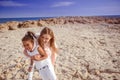 Beautiful top view of young mother playing with daughter with white hat at the sea background. Family vacation. Travel. Female Royalty Free Stock Photo