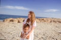 Beautiful top view of young mother playing with daughter with white hat at the sea background. Family vacation. Travel. Female Royalty Free Stock Photo