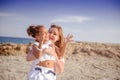 Beautiful top view of young mother playing with daughter with white hat at the sea background. Family vacation. Travel. Female Royalty Free Stock Photo