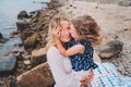 Portrait of happy mother and daughter spending time together on the beach on summer vacation. Happy family traveling, cozy mood. Royalty Free Stock Photo