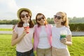 Portrait of happy mother and daughters teenagers 14 and 16 years old, girls with summer drinks. Background nature, recreation area Royalty Free Stock Photo