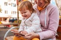 Portrait of a happy mother and her little daughter, reading a book together, sitting on a bench. The concept of child Royalty Free Stock Photo