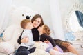 Portrait of a happy mother and her two little children - boy and girl. Happy family portrait. Little kids kissing mother Royalty Free Stock Photo