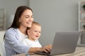 Portrait Of Happy Mother With Little Baby On Hands Using Laptop Together Royalty Free Stock Photo