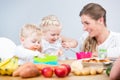 Portrait of a happy mother of two children sitting at table Royalty Free Stock Photo