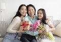 Portrait of happy multi generation Asian family with bouquet of tulips and gift box celebrating Mother& x27;s Day at home Royalty Free Stock Photo