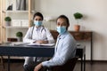 Happy multiethnic female doctor and male patient wearing face masks Royalty Free Stock Photo