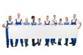 Happy Multiethnic Janitors Holding Blank Billboard Royalty Free Stock Photo