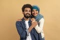 Portrait Of Happy Muslim Couple Embracing Over Beige Background Royalty Free Stock Photo