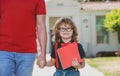 Portrait of happy nerd pupil holding teachers hand. Father and son walking trough school park, holding hand outdoors Royalty Free Stock Photo