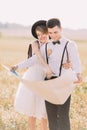 The portrait of the happy newlyweds. The groomd is holding the map while the vintage dressed bride is showing something