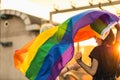 Young gender fluid couple in love waving a rainbow flag Royalty Free Stock Photo