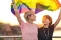 Young gender fluid couple in love waving a rainbow flag Royalty Free Stock Photo