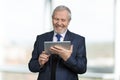 Portrait of happy old businessman using tablet. Royalty Free Stock Photo