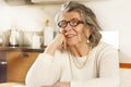 Portrait of a happy old woman sitting at the kitchen table Royalty Free Stock Photo