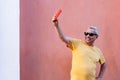 Portrait of a happy older man leaning against the wall and laughing Royalty Free Stock Photo