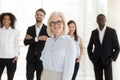 Portrait of happy older woman company ceo with diverse team Royalty Free Stock Photo