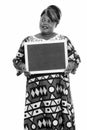 Portrait of happy overweight African woman thinking while holding blackboard Royalty Free Stock Photo