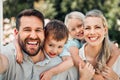 Portrait of happy parents giving their little children piggyback rides outside in a garden. Smiling caucasian couple Royalty Free Stock Photo
