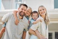 Portrait of happy parents giving their little children piggyback rides outside in a garden. Smiling caucasian couple Royalty Free Stock Photo