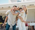 Portrait of happy parents giving their little children piggyback rides outside in a garden. Smiling caucasian couple Royalty Free Stock Photo