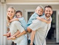 Portrait of happy parents giving their little children piggyback rides outside in a garden. Smiling caucasian couple Royalty Free Stock Photo