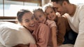 Portrait happy parents with two little daughters hugging on bed Royalty Free Stock Photo