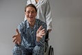 Doctor moving wheelchair with glad cripple