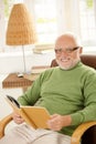 Portrait of happy pensioner relaxing with book Royalty Free Stock Photo