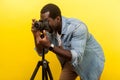 Portrait of happy photographer taking picture with professional digital dslr camera on tripod. indoor studio shot isolated on Royalty Free Stock Photo