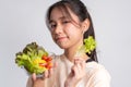 Portrait of a happy playful Asian girl eating fresh salad from a glass bowl after workout at home. Young lady Enjoying Healthy Royalty Free Stock Photo