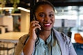 Portrait of happy plus size african american casual businesswoman talking on smartphone in office Royalty Free Stock Photo