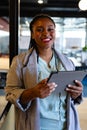 Portrait of happy plus size african american casual businesswoman using tablet in office Royalty Free Stock Photo